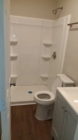 a bathroom with a sink a toilet and shower