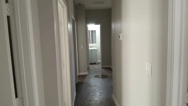 a view of a hallway with wooden floor
