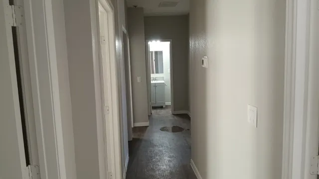 a view of a hallway with wooden floor