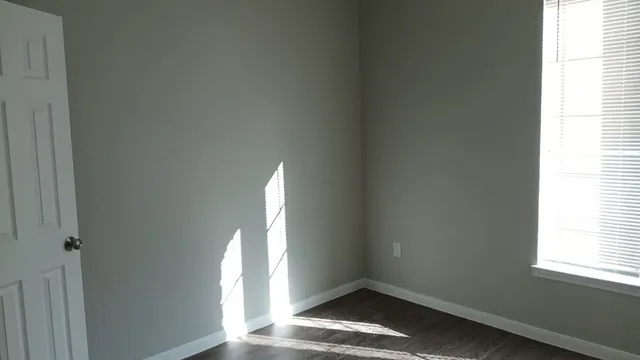 a view of a small space with wooden floor and a window