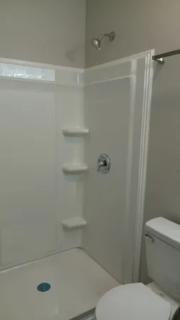 a bathroom with a toilet and a shower