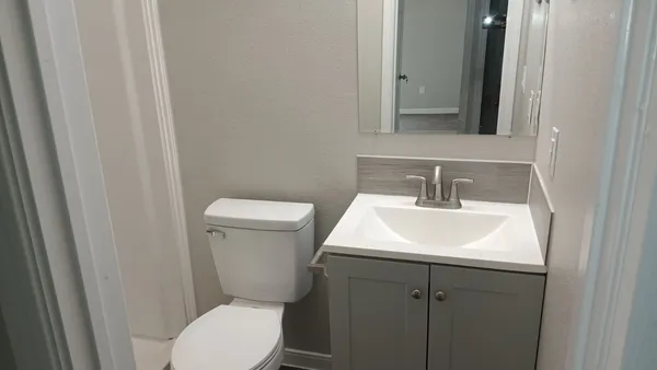 a bathroom with a toilet sink and mirror