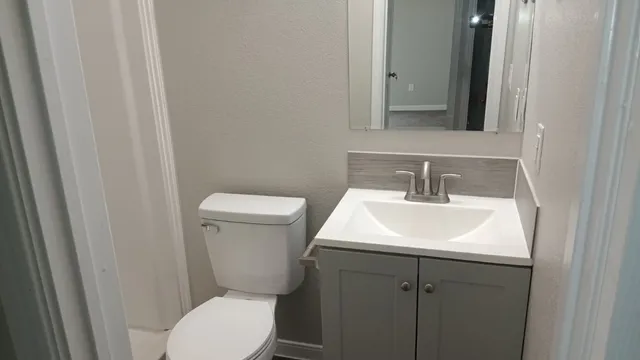 a bathroom with a toilet sink and mirror