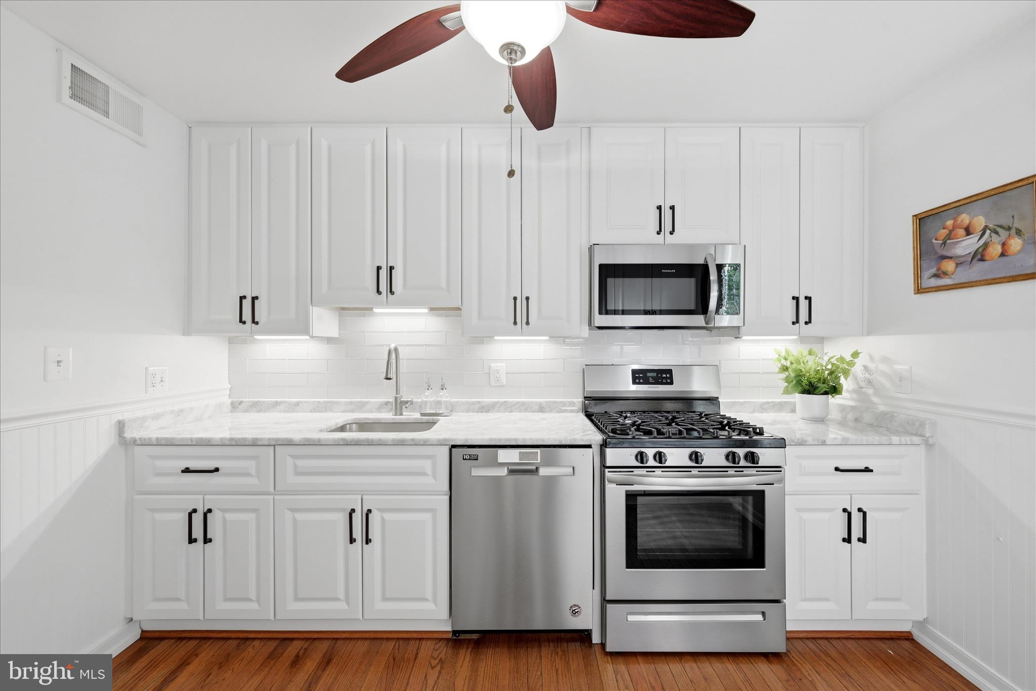 5446 Lighthouse Lane Burke, VA 22015 - Photo 6 of 36 a kitchen with stainless steel appliances white cabinets a stove a sink and a microwave