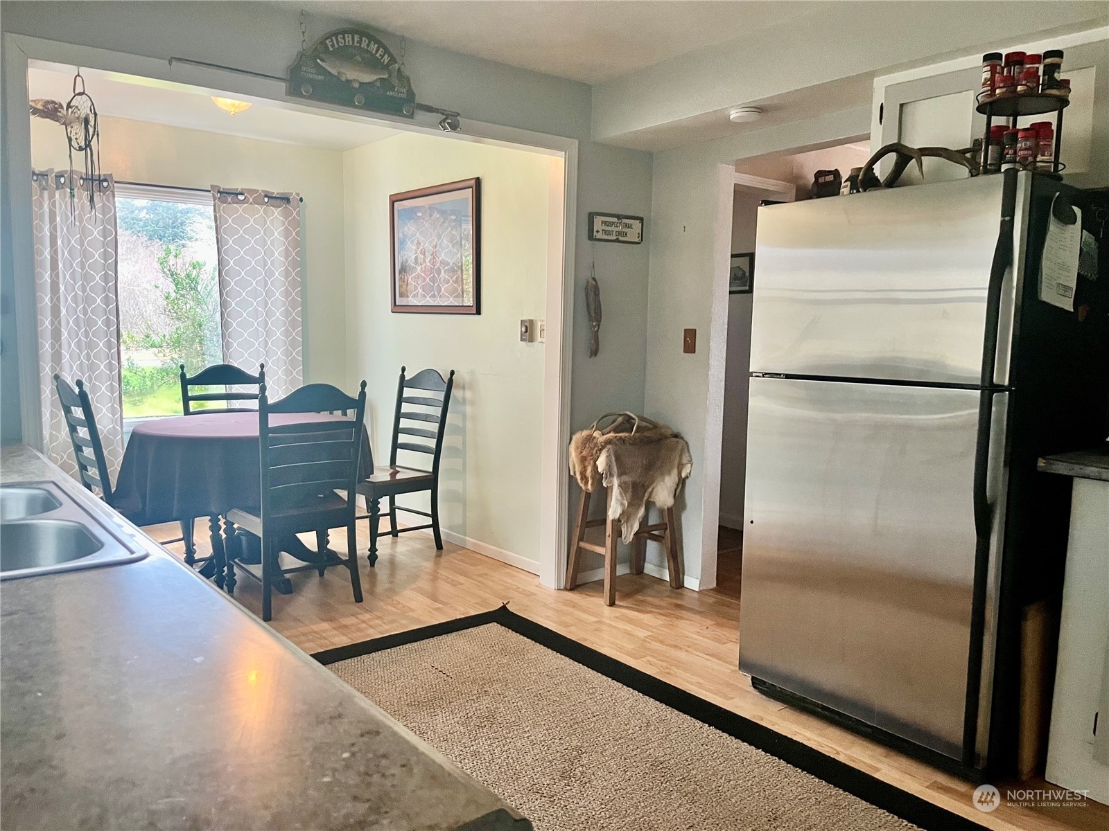 2998 Alexson Road Grayland, WA 98547 - Photo 7 of 27 a kitchen with a refrigerator a dining table and chairs