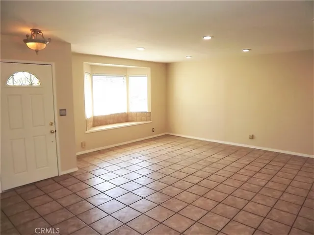 an empty room with windows and a chair