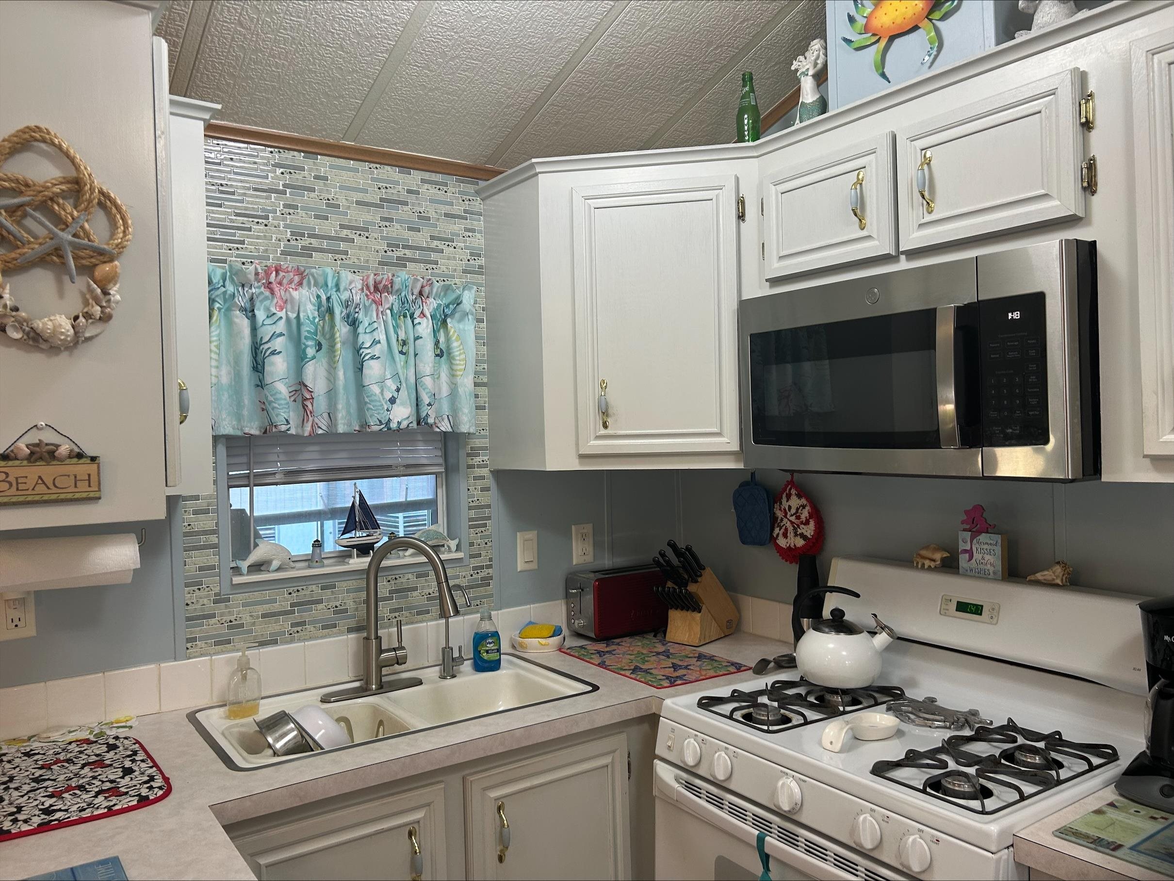 709 Us Rt 9 S, Unit 623 Cape May, NJ 08204 - Photo 3 of 10 a kitchen with stainless steel appliances granite countertop a sink stove and cabinets