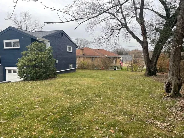 a view of a yard with a house and a tree