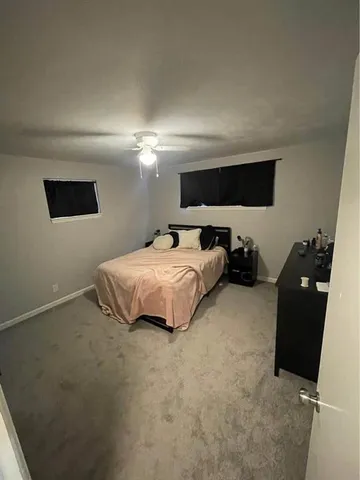 a bedroom with bed and a flat tv screen on dresser