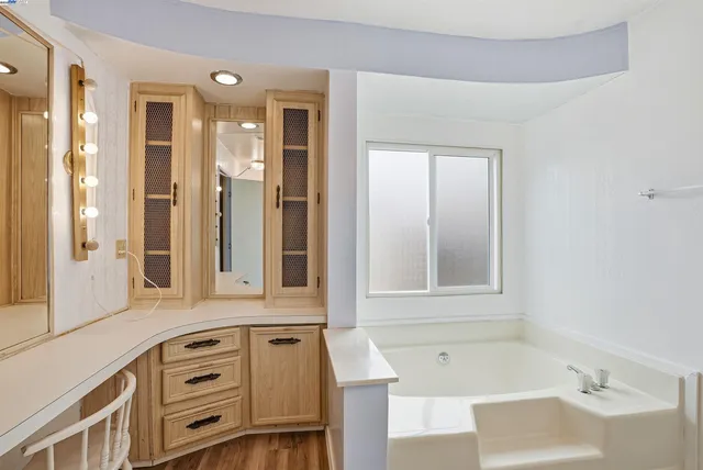 a bathroom with a tub sink and mirror