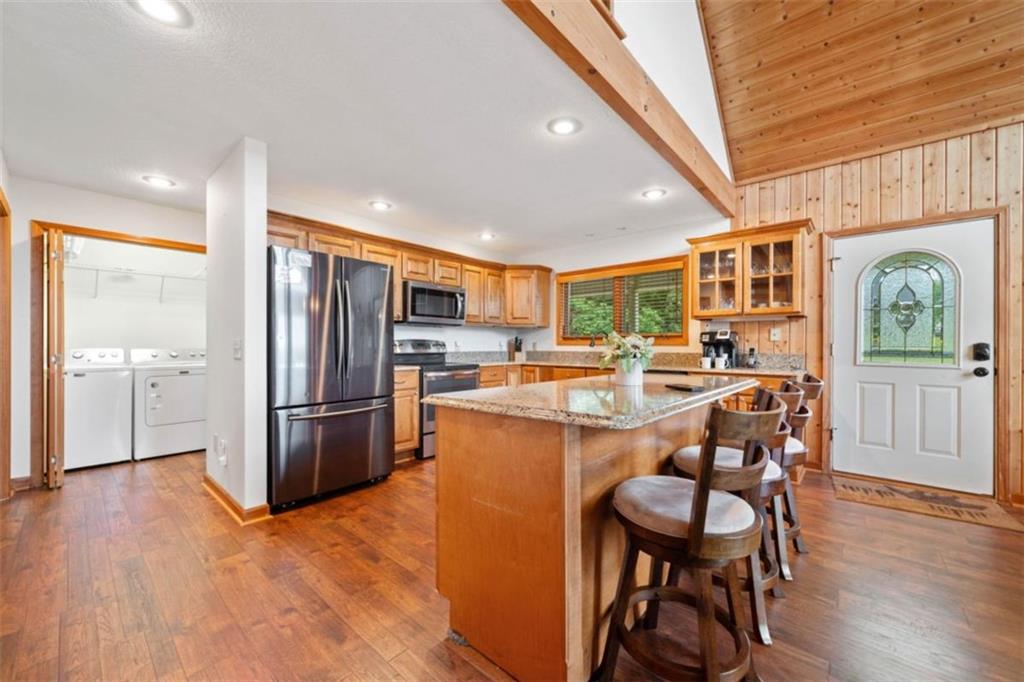 82 Emelia Road Morganton, GA 30560 - Photo 12 of 45 a kitchen with stainless steel appliances kitchen island granite countertop a refrigerator a stove a sink a dining table and chairs with wooden floor