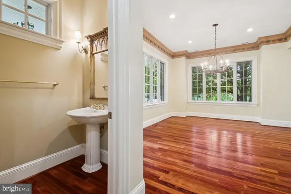 a view of hallway with wooden floor and fan