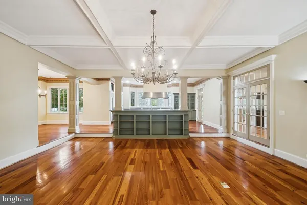 a view of an empty room with wooden floor and a fireplace