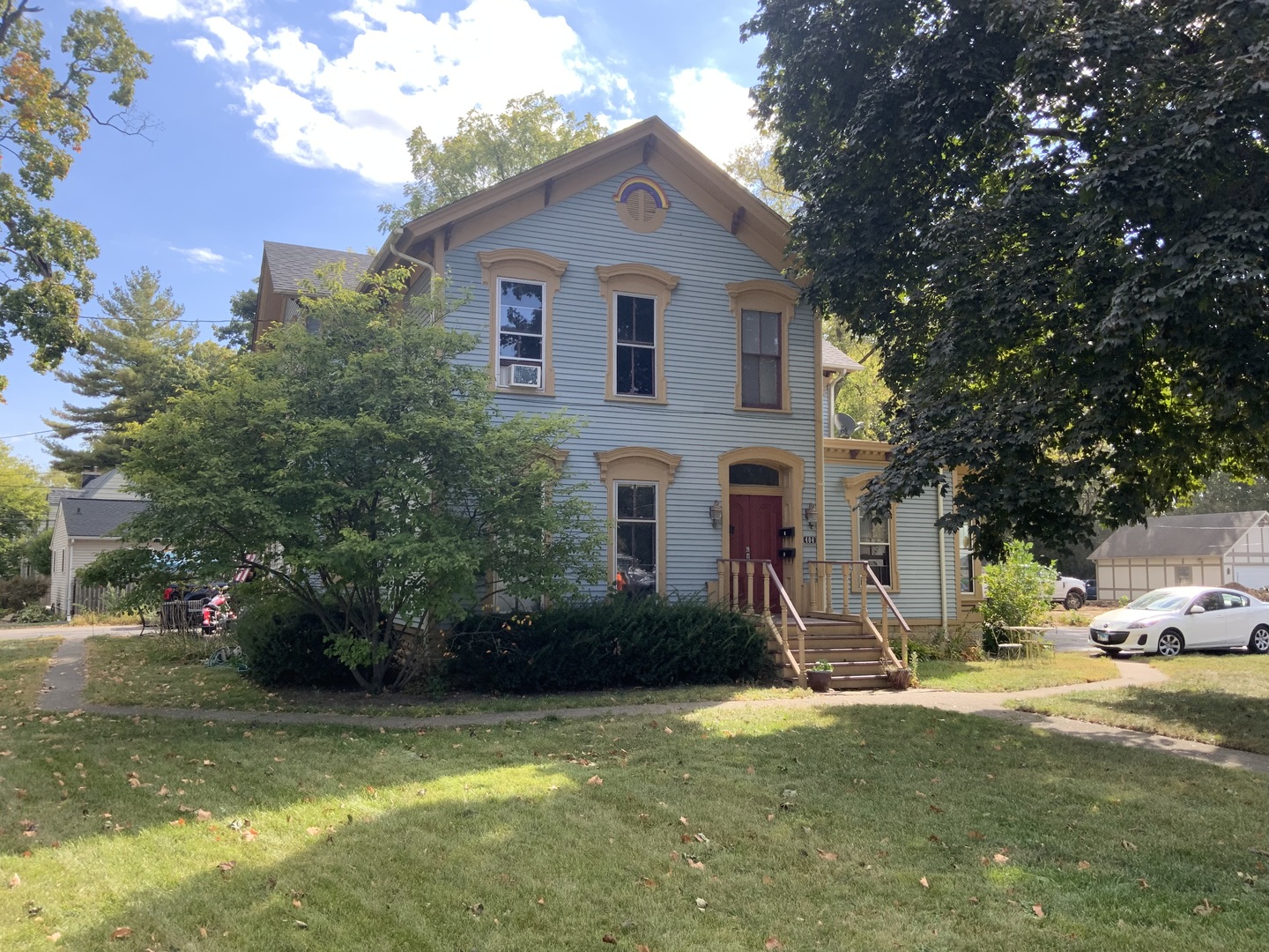 a front view of a house with a garden and trees
