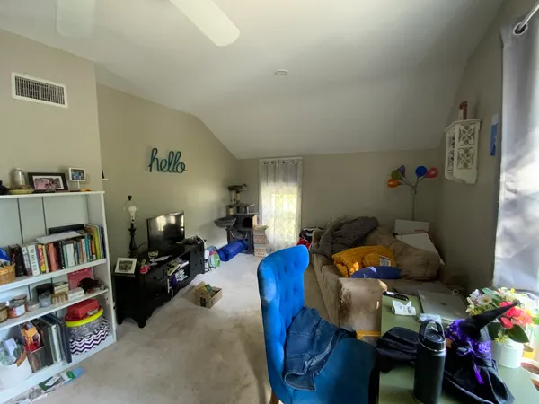 a living room with furniture a baby crib and a book shelf