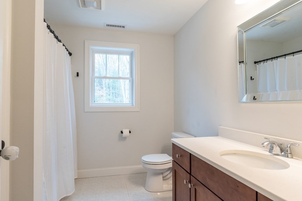 188 South Road Pepperell, MA 01463 - Photo 22 of 41 a bathroom with a granite countertop toilet a sink a mirror and a window
