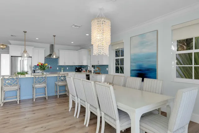 a kitchen with stainless steel appliances granite countertop a dining table chairs stove and cabinets