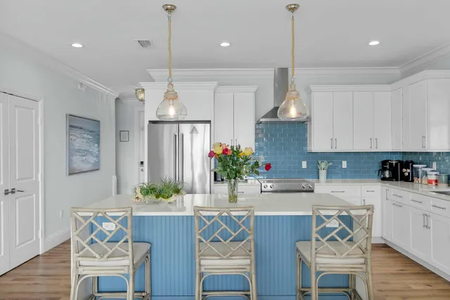 a kitchen with a dining table chairs refrigerator and cabinets