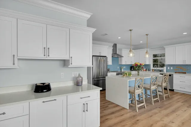 a kitchen with refrigerator and chairs
