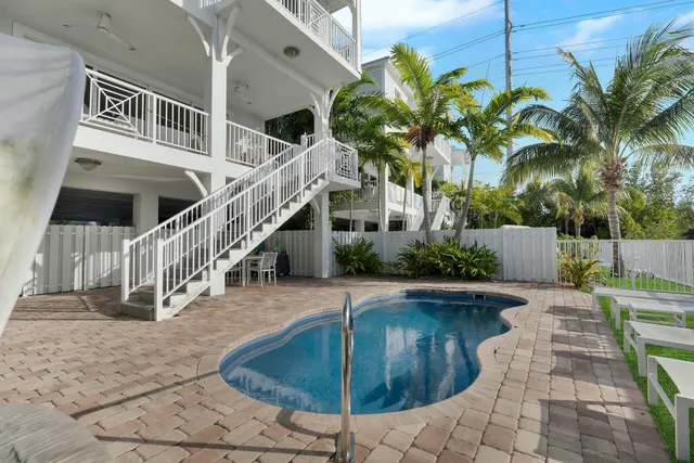 a view of a house with backyard and swimming pool