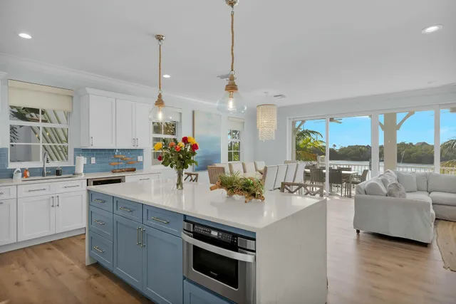a kitchen with a sink dishwasher a stove and white cabinets with wooden floor