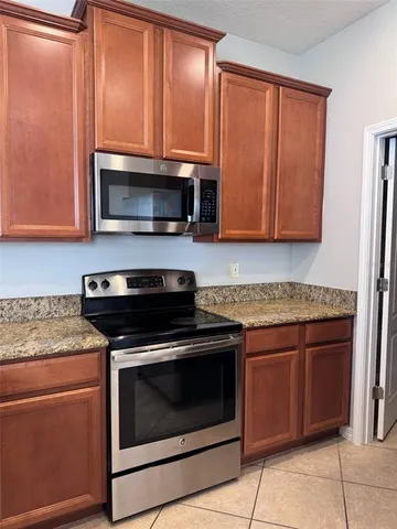 a kitchen with granite countertop cabinets stainless steel appliances and wooden cabinets