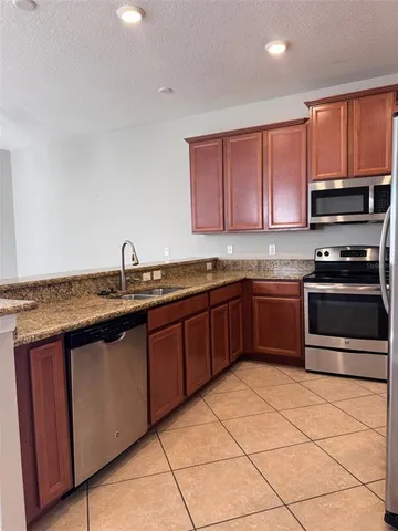 a kitchen with stainless steel appliances granite countertop a stove a sink and a microwave