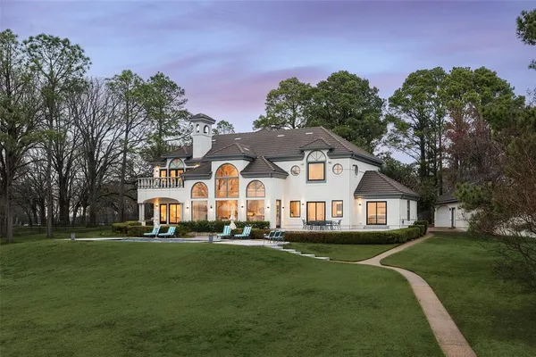a front view of a house with a garden and trees