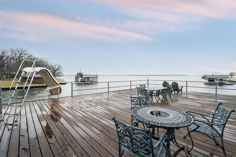 a view of a roof deck with table and chairs with wooden floor