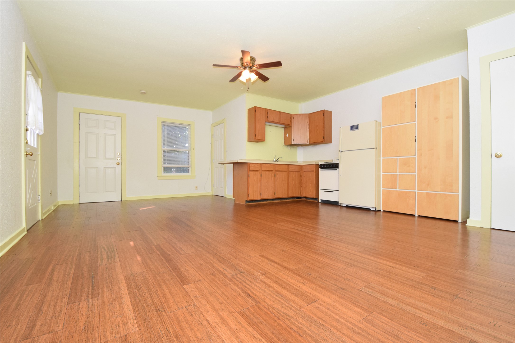 2801 Lafayette Avenue, Unit B Austin, TX 78722 - Photo 2 of 13 Unfurnished living room with light wood-type flooring, baseboards, ceiling fan, and a sink