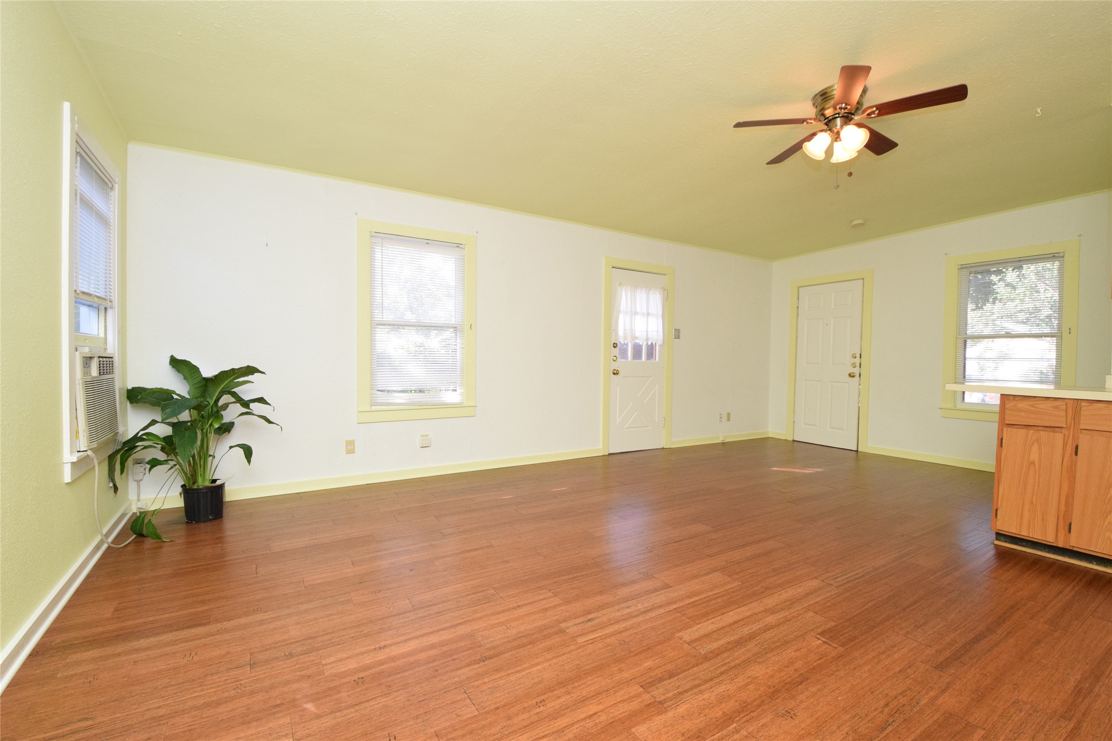 2801 Lafayette Avenue, Unit B Austin, TX 78722 - Photo 3 of 13 Unfurnished living room featuring a ceiling fan, wood finished floors, and a healthy amount of sunlight