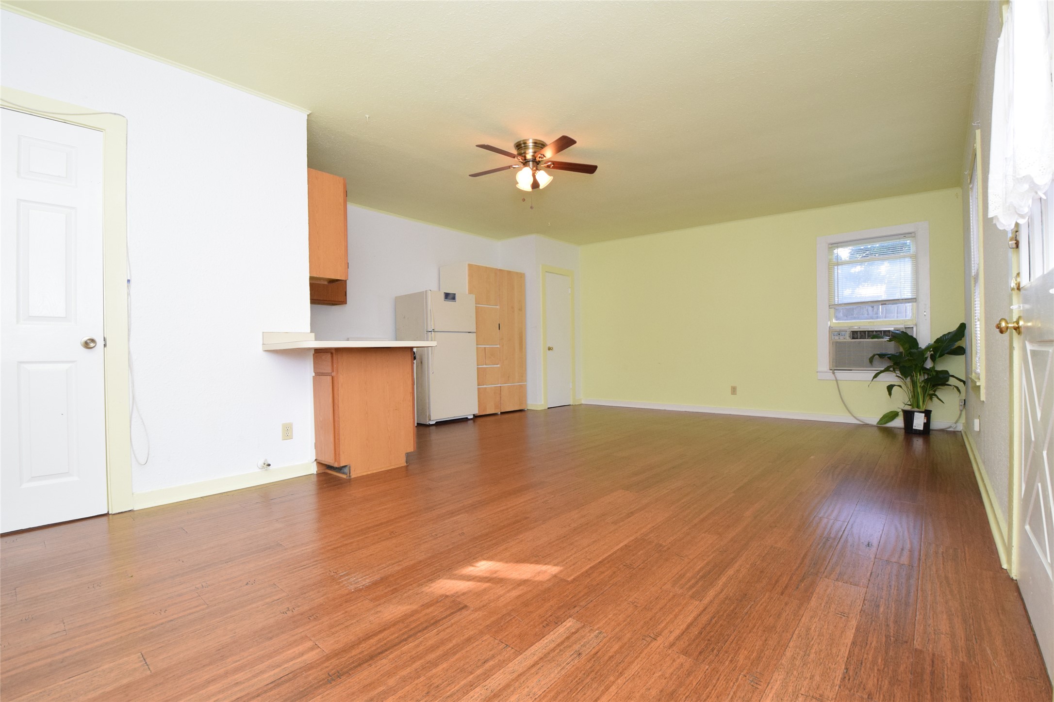 2801 Lafayette Avenue, Unit B Austin, TX 78722 - Photo 4 of 13 Unfurnished living room featuring cooling unit, baseboards, a ceiling fan, and wood finished floors