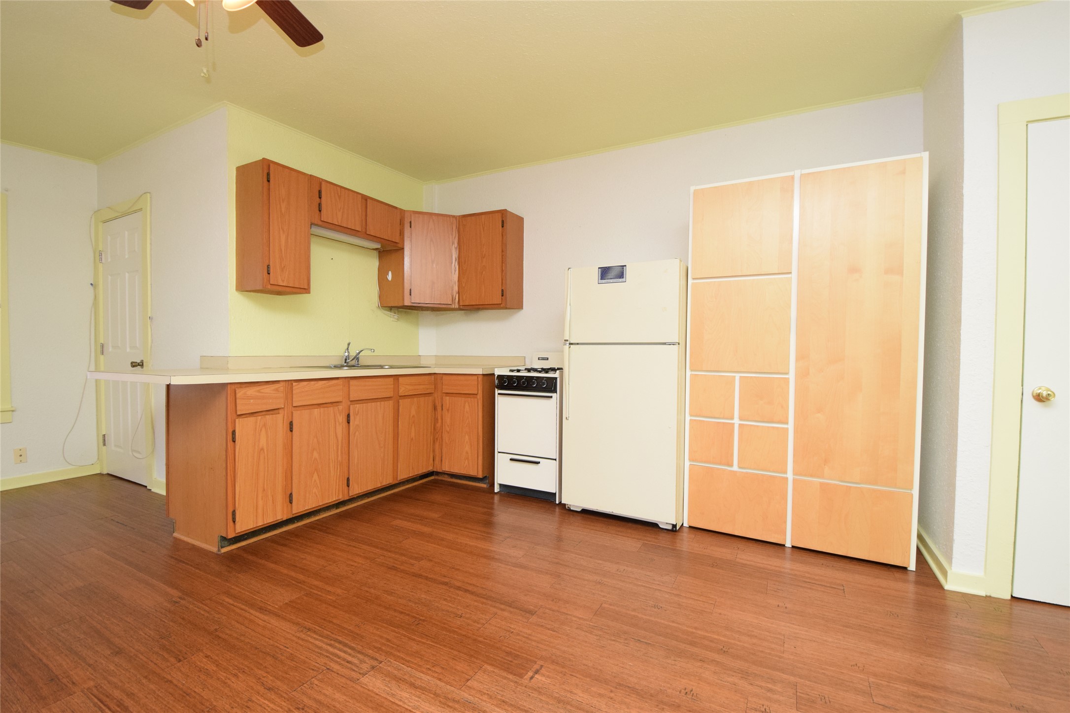 2801 Lafayette Avenue, Unit B Austin, TX 78722 - Photo 5 of 13 Kitchen featuring wood finished floors, a ceiling fan, and white appliances