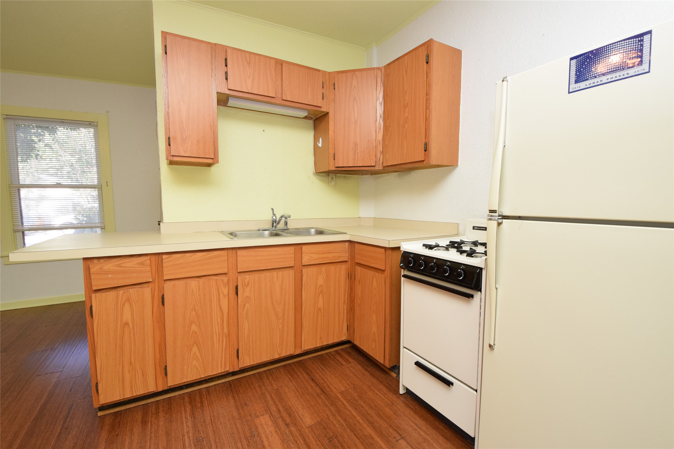 2801 Lafayette Avenue, Unit B Austin, TX 78722 - Photo 6 of 13 Kitchen with crown molding, a sink, white appliances, light countertops, and dark wood-style flooring