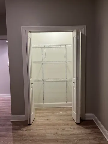 an empty room with wooden floor and closet