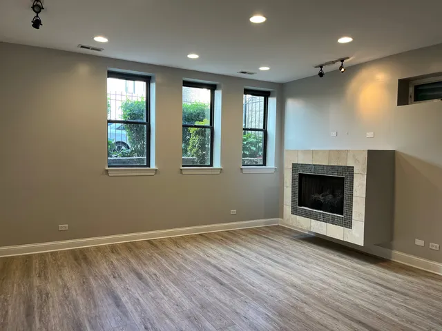 a view of an empty room with a window and fireplace