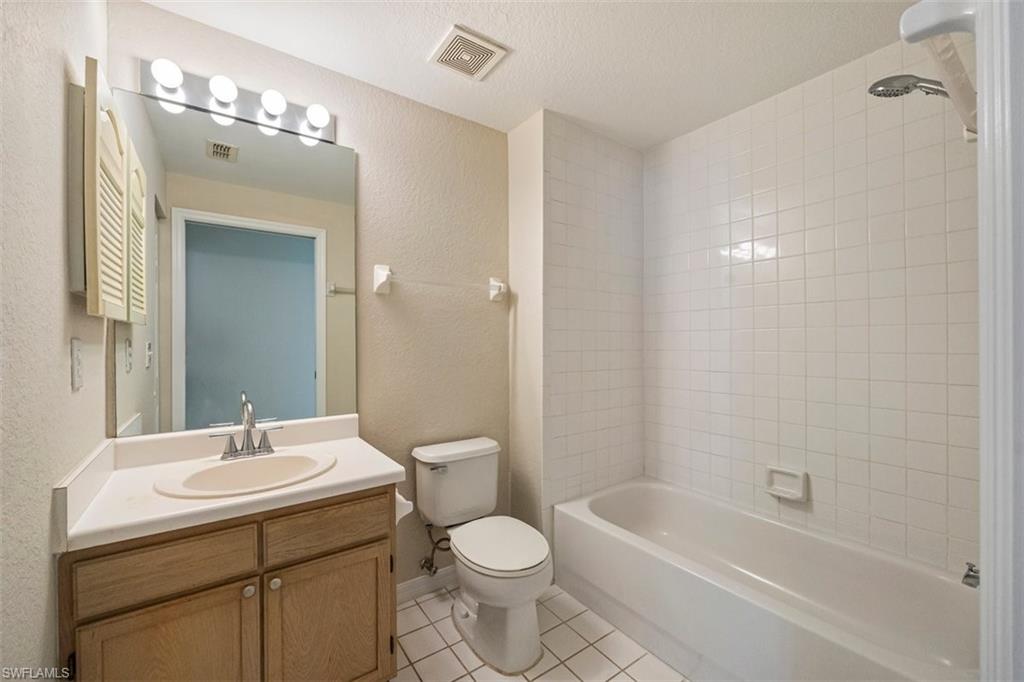 4635 St Croix Lane, Unit 1218 Naples, FL 34109 - Photo 20 of 40 Full bath featuring tile patterned flooring, vanity, shower / bathtub combination, and a textured wall