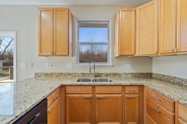 a kitchen with granite countertop cabinets sink and window