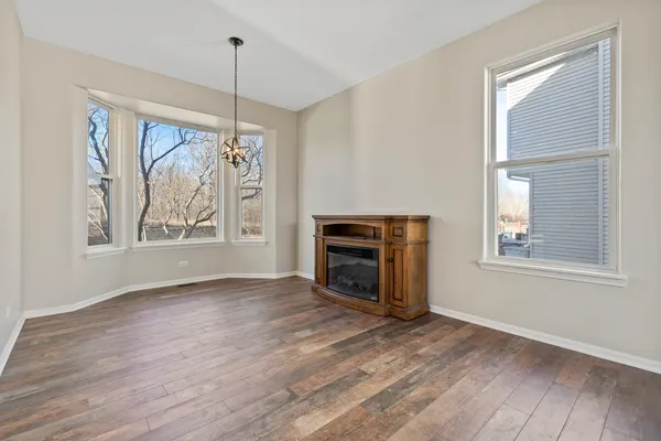 a view of empty room with wooden floor fireplace and windows