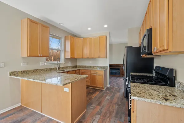 a kitchen with a sink stove top oven and refrigerator