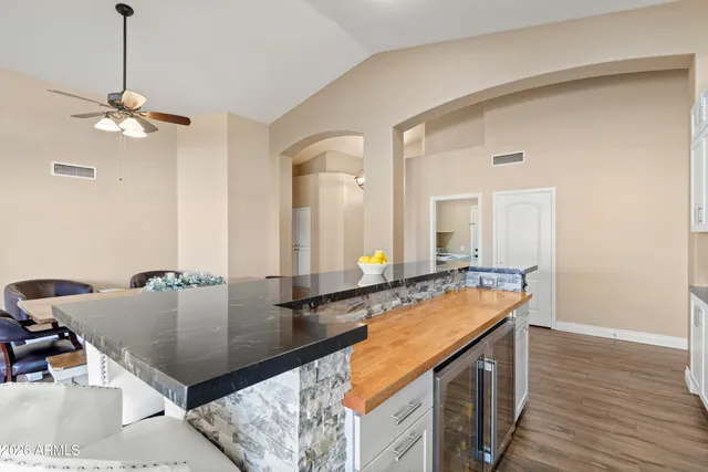 a kitchen with stainless steel appliances kitchen island granite countertop a stove and white cabinets