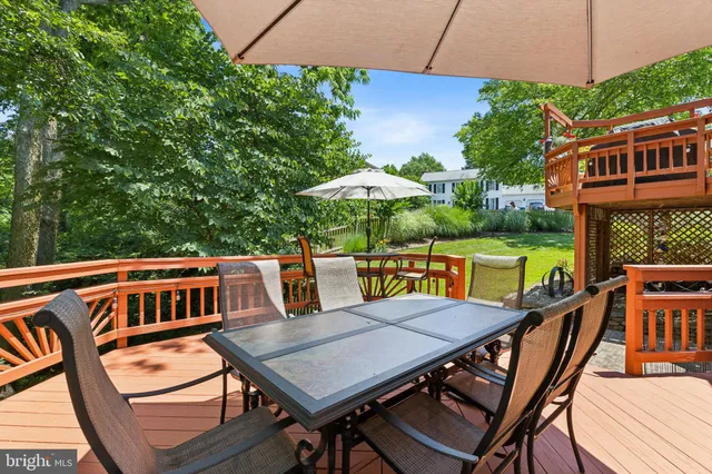 a view of a patio with table and chairs potted plants with wooden floor and fence