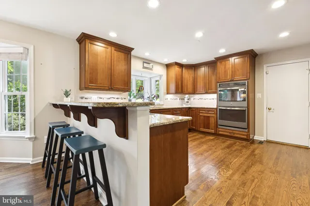 a kitchen with kitchen island a large counter top space appliances and a center island