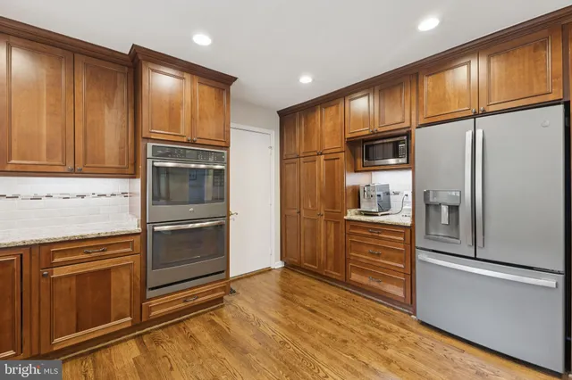 a kitchen with granite countertop stainless steel appliances a refrigerator and cabinets