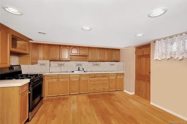 a kitchen with granite countertop a stove top oven and cabinets