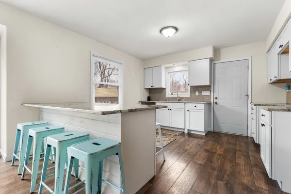 a kitchen with cabinets a sink a window and stainless steel appliances
