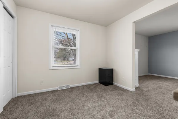 an empty room with windows and closet