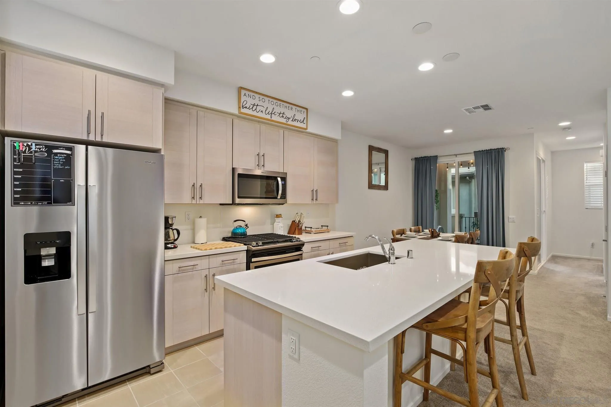 1150 Via Lucero Oceanside, CA 92056 - Photo 21 of 36 a kitchen that has a lot of cabinets a sink and a refrigerator in it
