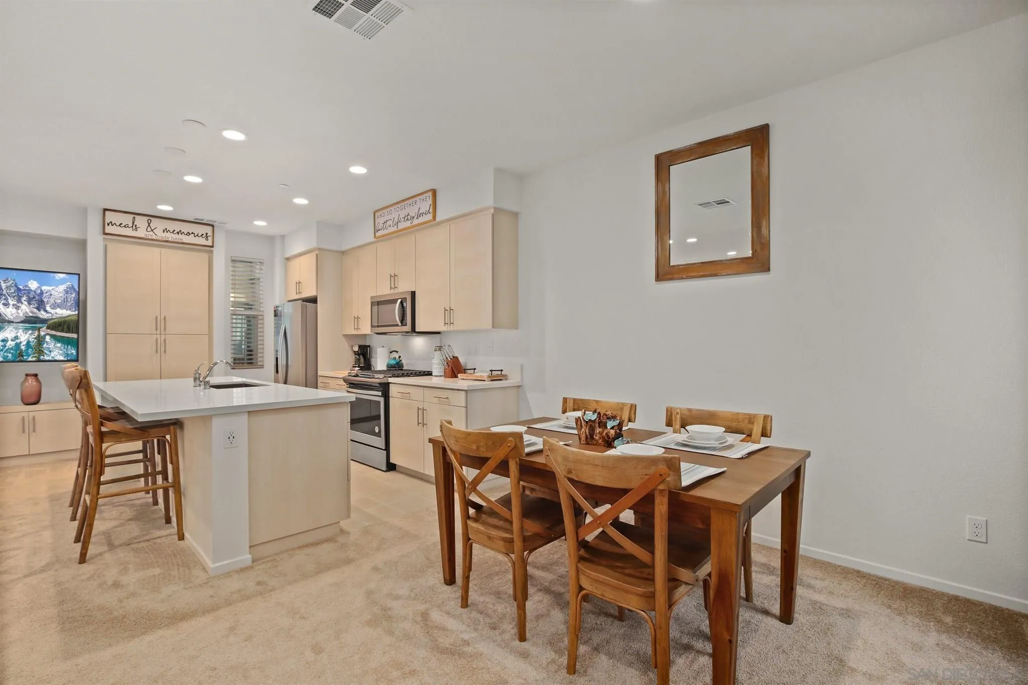 1150 Via Lucero Oceanside, CA 92056 - Photo 29 of 36 a kitchen with a dining table chairs and refrigerator