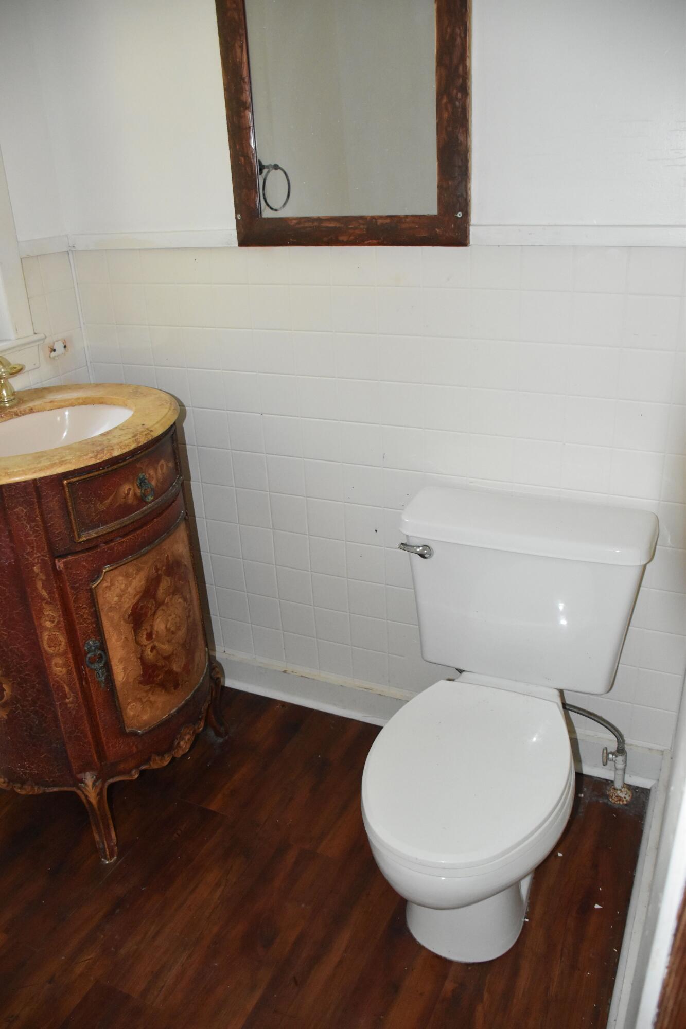 326 Dixie Street Crestview, FL 32536 - Photo 2 of 10 a bathroom with a toilet a sink and wooden floor